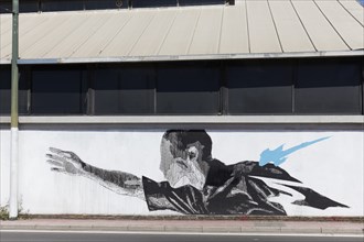 Man with outstretched arm, surreal mural in black and white by Greek street artist INO, Gazi