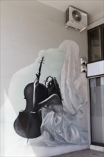 Woman in white dress with cello, cellist, mural by the Greek street artist Nozo, Kerameikos