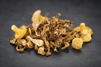 Portion of Dried Chanterelles on a rustic slate slab, selective focus, close-up shot