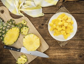 Sliced Pineapple on rustic wooden background as close-up shot