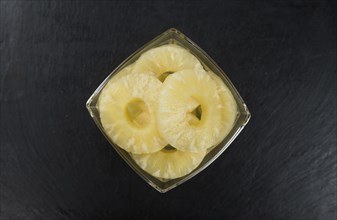 Preserved Pineapple Rings on a vintage slate slab as detailed close-up shot, selective focus