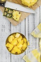 Sliced Pineapple on an old wooden table as detailed close-up shot, selective focus