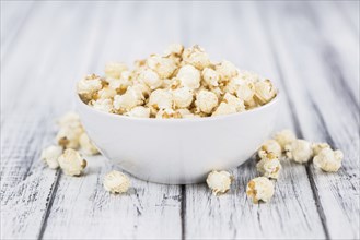 Popcorn as high detailed close-up shot on a vintage wooden table, selective focus