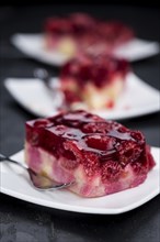 Fresh made Raspberry Cake on a rustic slate slab (close-up shot, selective focus)