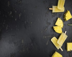 Fresh made Popsicles (Pineapple flavoured, selective focus) on a rustic background