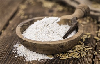 Vintage wooden table with Oat Flour (selective focus, close-up shot)