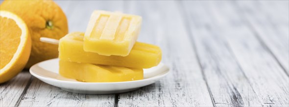 Some fresh made Popsicles (close-up shot, selective focus) on a wooden background