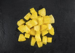 Portion of Pineapple (sliced) on a rustic slate slab, selective focus, close-up shot