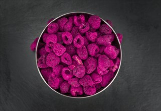 Dried Raspberries on a vintage slate slab as detailed close-up shot, selective focus