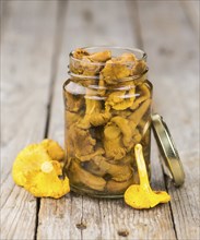 Canned chanterelles on a vintage background as detailed close-up shot, selective focus