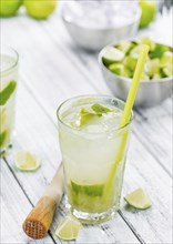 Vintage wooden table with Caipirinha (selective focus, close-up shot)