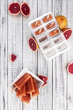 Some freshly made Grapefruit Popsicles (with some fresh fruits, selective focus)