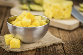 Sliced Pineapple on rustic wooden background as close-up shot