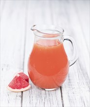 Some freshly squeezed Grapefruit Juice on a vintage background (close-up shot, selective focus)