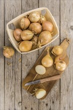 White Onions on rustic wooden background as close-up shot