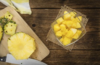 Sliced Pineapple on an old wooden table as detailed close-up shot, selective focus