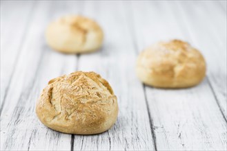 Fresh made German Buns on an old and rustic wooden table, selective focus, close-up shot