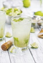 Caipirinha made with fresh limes, ice and sugar as close-up shot