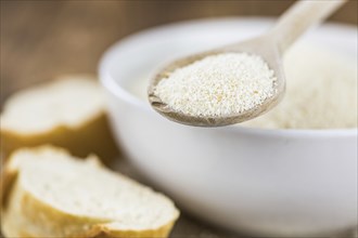 Some Bread Crumbs on a vintage wooden table (selective focus, close-up shot)