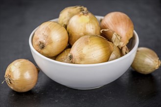 Portion of White Onions as detailed close up shot on a slate slab, selective focus