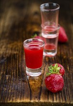 Homemade Strawberry liqueur on vintage background selective focus, close-up shot