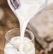 Wooden table with Oat Milk (detailed close-up shot, selective focus)