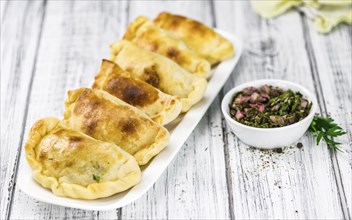 Portion of healthy Empanadas on an old wooden table (selective focus, close-up shot)