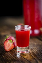 Homemade Strawberry liqueur on vintage background selective focus, close-up shot