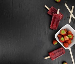 Strawberry Popsicles (close-up shot, selective focus) on a rustic background