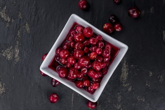 Healthy Canned Cranberries on a vintage slate slab (close-up shot, selective focus)