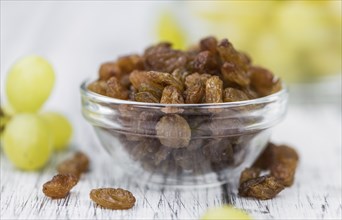 Vintage wooden table with Raisins (selective focus, close-up shot)