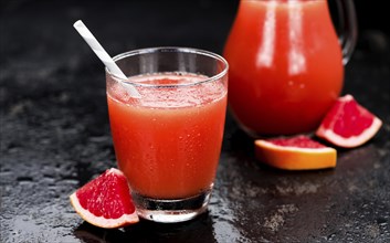 Some freshly squeezed Grapefruit Juice on a vintage background (close-up shot, selective focus)