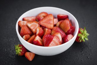 Sliced Strawberries on a vintage slate slab as detailed close-up shot, selective focus