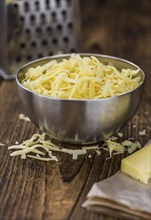 Old wooden table with grated Cheese (close-up shot)