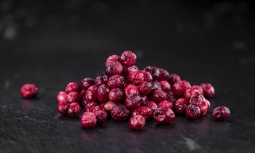 Portion of healthy Dried Cranberries on a slate slab (selective focus)