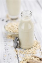 Wooden table with Oat Milk (detailed close-up shot, selective focus)