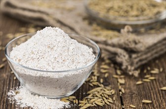 Some Oat Flour on a vintage wooden table (selective focus, close-up shot)