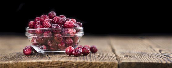 Dried Cranberries on an old wooden table (selective focus)