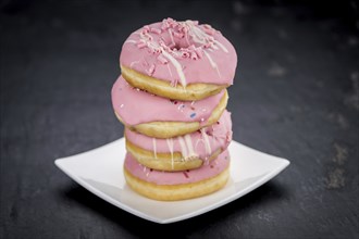 Portion of pink glazed Donuts (detailed close-up shot)