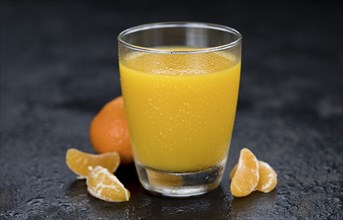 Homemade Tangerine Juice (close-up shot, selective focus) on a rustic background