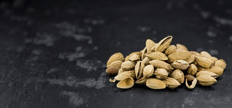 Dark slate slab with roasted and salted Almonds (in the shell)