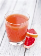 Portion of freshly squeezed Grapefruit Juice on a vintage background (selective focus, close-up