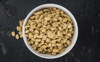 Roasted and salted Peanuts on vintage background (close-up shot, selective focus)