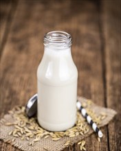 Healthy Oat Milk on a wooden table as detailed close-up shot (selective focus)