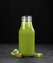 Some fresh homemade Kiwi Smoothies on a slate slab (close-up shot, selective focus)