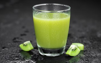 Some fresh homemade Kiwi Smoothies on a slate slab (close-up shot, selective focus)