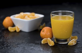 Portion of fresh made Tangerine Juice (close-up shot, selective focus)