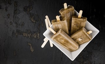 Slate slab with cola popsicles (homemade) as detailed close-up shot (selective focus)