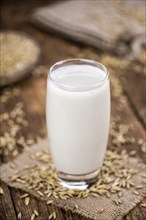 Healthy Oat Milk on a wooden table as detailed close-up shot (selective focus)