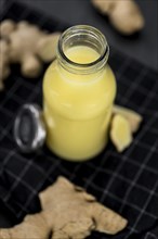 Fresh made Ginger Drink on a slate slab (close-up shot, selective focus)